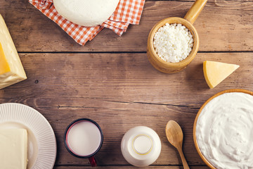 Variety of dairy products laid on a wooden table background