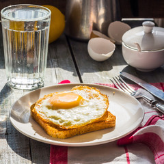 crispy toast with a fried egg and a glass of water, lemon, break