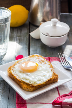 crispy toast with a fried egg and a glass of water, lemon, break