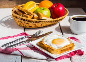 crispy toast with a fried egg and a cup of coffee, fruit, breakf