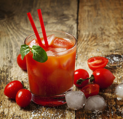 Red cocktail with tomato juice, ice and salt, selective focus
