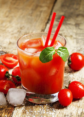 Red cocktail with tomato juice, ice and salt, selective focus