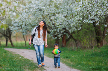 Mother and son walking along the blossoming spring garden