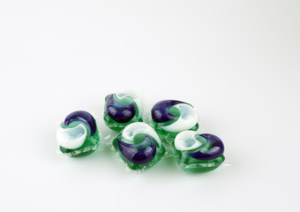 Gel capsules with laundry detergent on a white background