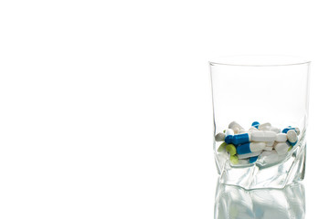Wasserglas mit Tabletten gefüllt