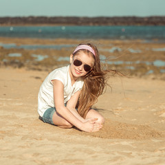 little girl in a hat on the  beach