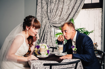 Bride and groom in luxurious restaurant drink a cup of Coffee