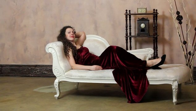 Woman in vintage room posing on sofa