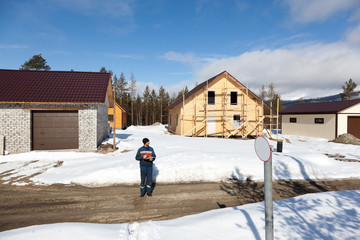 Worker in overalls making notes on construction site