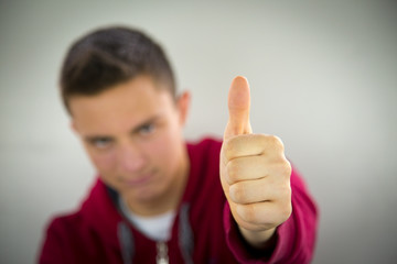 Portrait of teenage boy showing OK sign