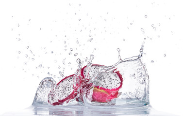 Fresh dragon fruit in water splash on white