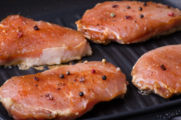 grilled pork steak in a frying pan during cooking
