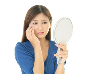 顔のシミを気にする女性