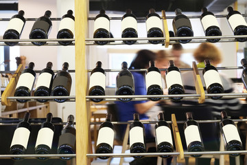 Naklejka na ściany i meble Bottles of red wine on a wooden shelf in the restaurant