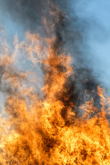Fototapeta na wymiar Big fire and flames with a blue sky