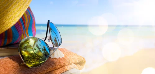 Fototapeten Strohhut, Tasche und Sonnenbrille an einem tropischen Strand © Konstiantyn