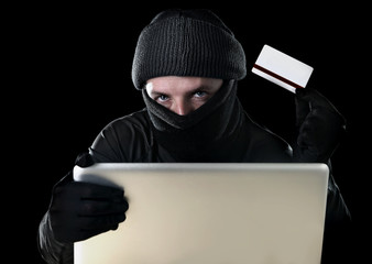 hacker man with credit card and computer in  cyber crime concept