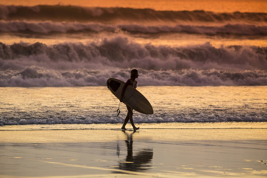 Surfer on the Beach at Sunset Tme
