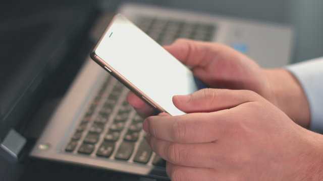 Closeup of male hands scrolling, typing message on smartphone