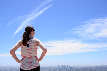 Woman with ponytail looking at city skyline
