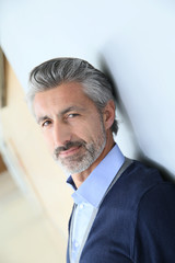 Portrait of smiling mature man standing in corridor