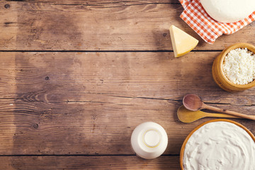 Variety of dairy products laid on a wooden table background