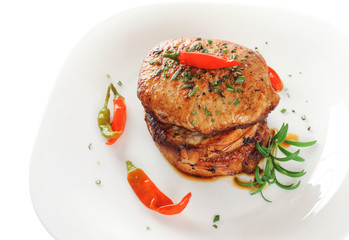 Steak with rosemary and chili pepper on a plate
