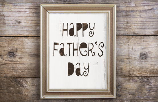 Picture frame with Happy fathers day sign on wooden backround.