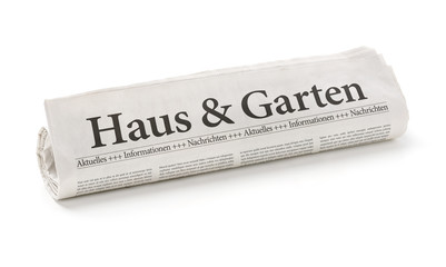 Zeitungsrolle mit der Überschrift Haus und Garten