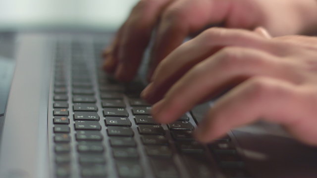 Close up of male fingers pressing laptop buttons, using touchpad