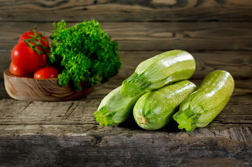 Zucchini, tomatoes and parsley on wooden background. Zucchini cl