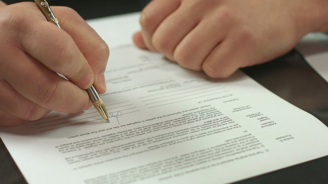 Male hand signing pages of contract, work with official document