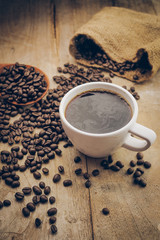 cup of coffee and coffee bean on the wood desk