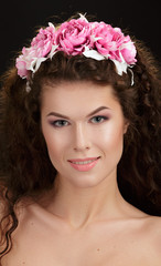 Naklejka premium Portrait of a beautiful spring girl wearing flowers wreath.