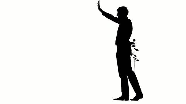 A man hiding a secret rose for his date. Silhouette 