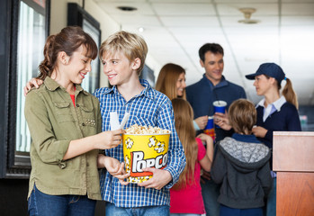 Brother And Sister Holding Popcorn At Cinema