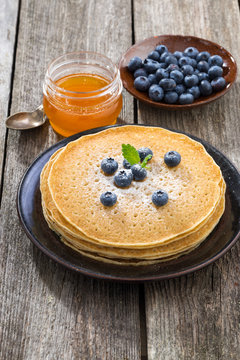 crepes with fresh blueberries and honey, vertical