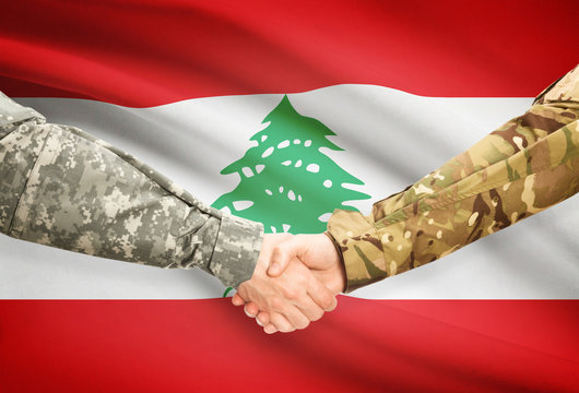 Men in uniform shaking hands with flag on background - Lebanon