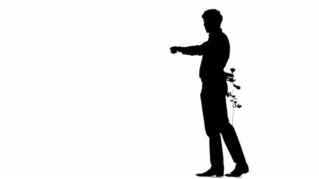 A man hiding a secret rose for his date. Silhouette. Slow motion