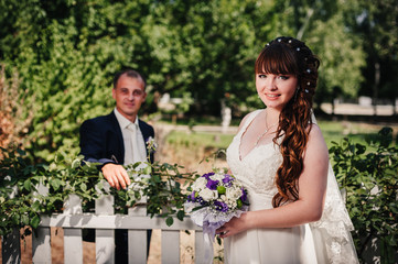 wedding couple kissing in green summer park. bride and groom