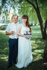 wedding couple kissing in green summer park. bride and groom