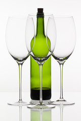 Three empty glasses of wine and green bottle