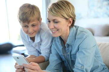 Mother and pre-teen using smartphone at home