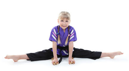 Obraz premium Little girl in kimono doing exercises isolated on white