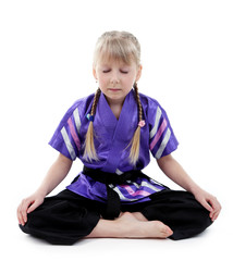 Little girl in kimono doing exercises isolated on white