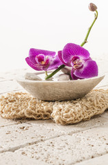 Obraz na płótnie Canvas loofah glove with orchid flowers for spa treatment