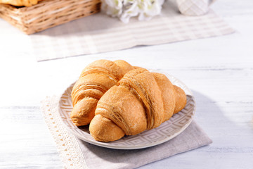 Delicious croissants on plate on table close-up