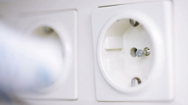 close up of hand with screwdriver fixing socket