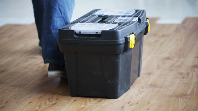 close up of man carrying tool box and leaving it