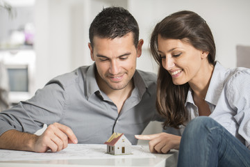 Obraz premium young couple examing blueprints of they new house